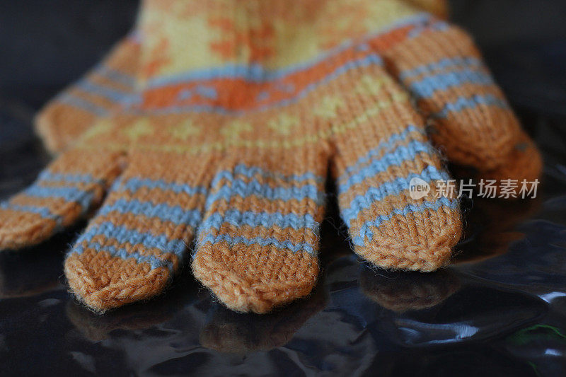 一只橙色的羊毛冬季手套，用来防雪