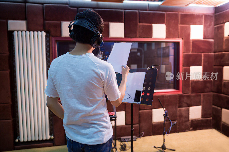 一个年轻的歌手在录音室录制一个轨道的特写