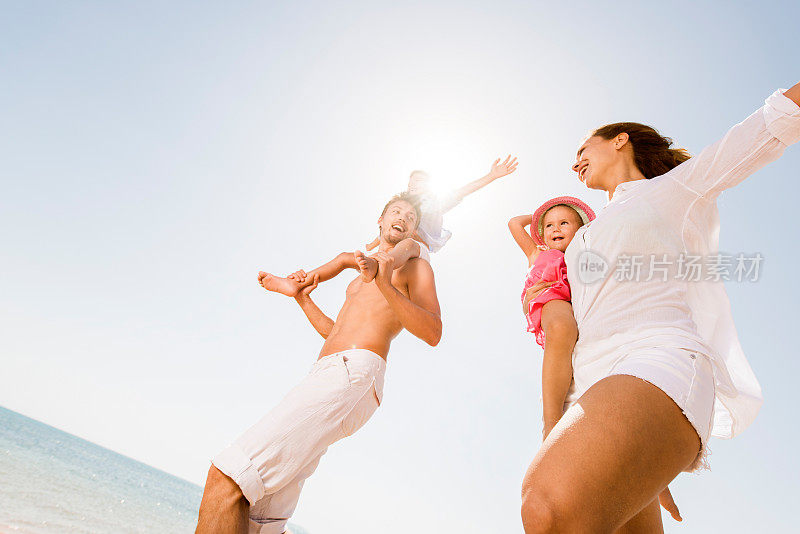 快乐的家庭在夏天对着天空玩。
