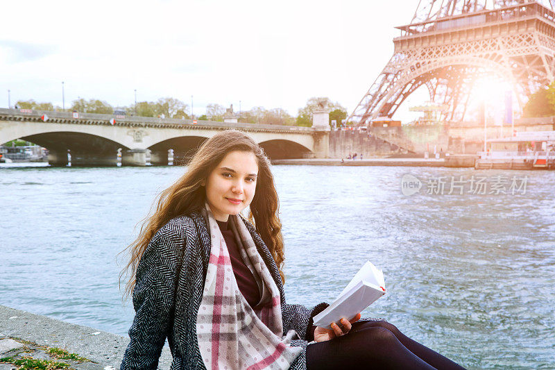 一位法国妇女在塞纳河附近看书
