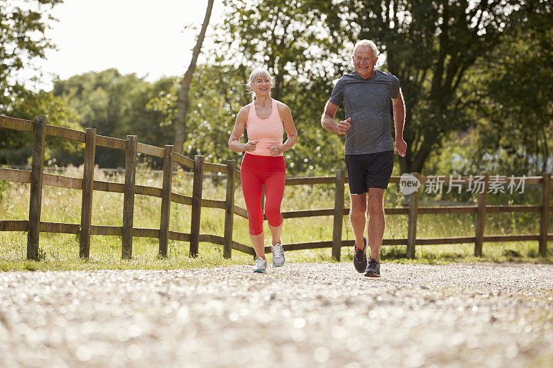 健康的老年夫妇一起在乡村跑步
