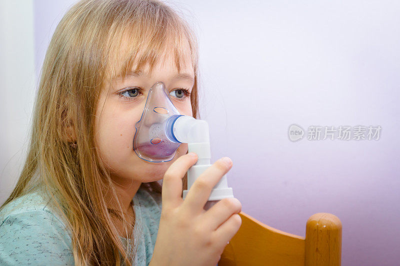 可爱小女孩用吸入器的肖像