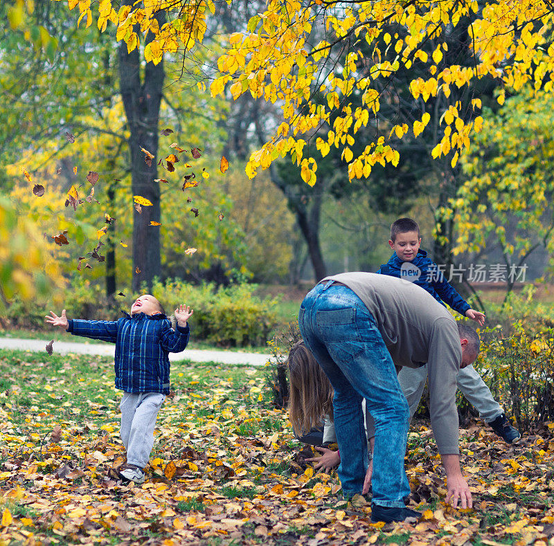 快乐的一家人在秋天的公园里玩耍