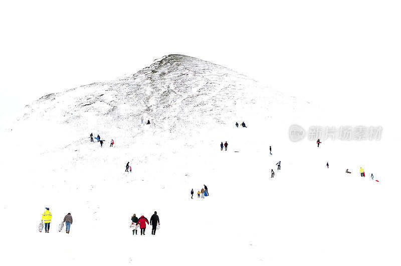 非常小的不知名的人在雪地里玩