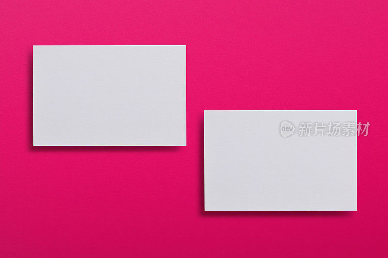 模拟两个水平的白色名片在粉红色的纹理纸背景。品牌标识的模拟模板。用于图形设计师的演示文稿和作品集