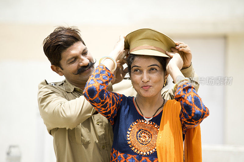 一名印度警察，妻子戴着帽子