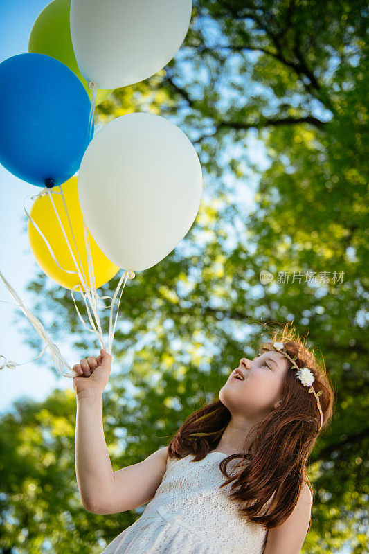 美丽的小女孩在公园里玩气球
