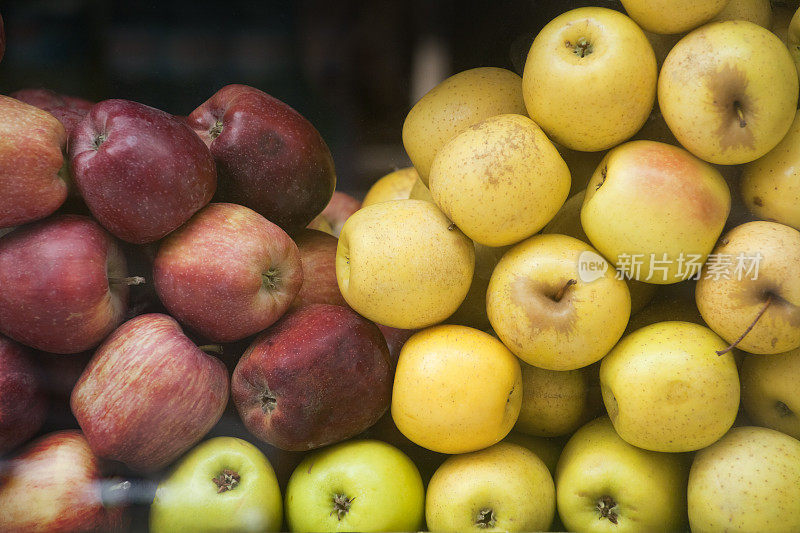 蔬菜水果商，一堆堆红黄相间的苹果。