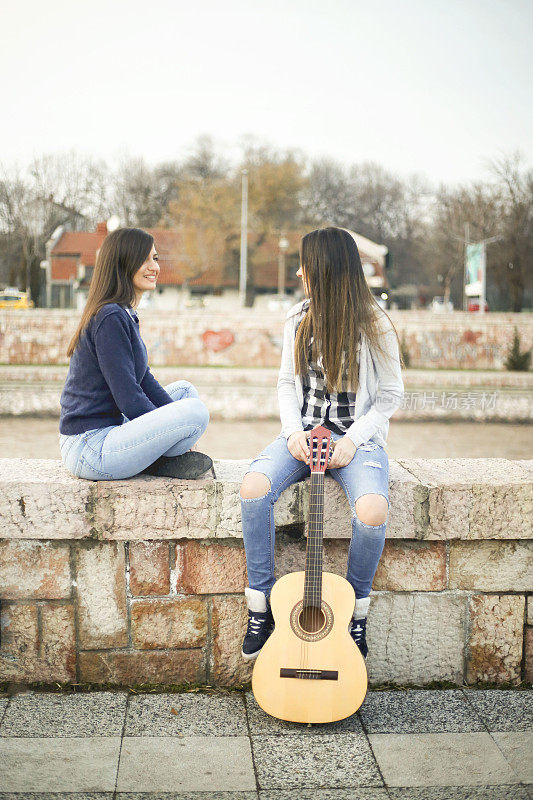 两个年轻女子在户外弹吉他