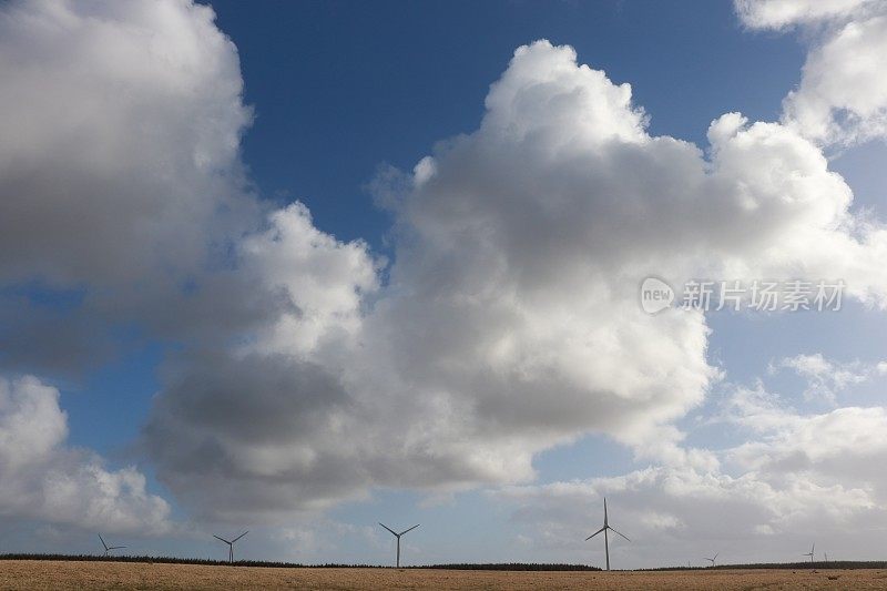 蓝天下的风力涡轮机和蓬松的白云