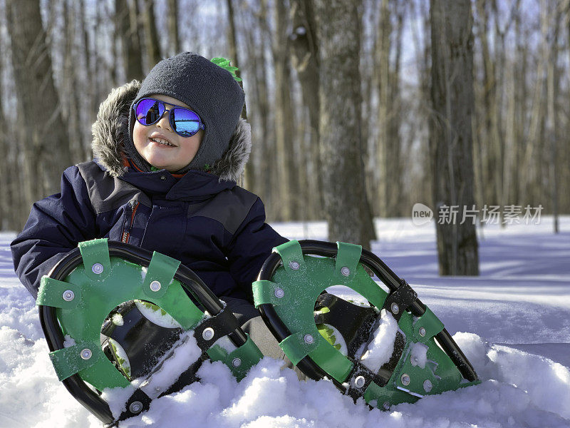 在暴风雪后的冬天，男孩在户外穿雪鞋