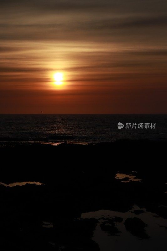 日出越过岩石和大海