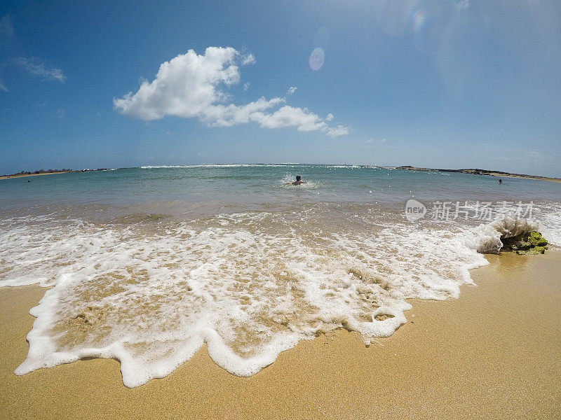 在天堂里游泳，孩子们在考艾岛的海洋里游泳，在荒芜的海滩上玩耍