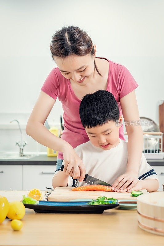 老女人和儿子在厨房切三文鱼