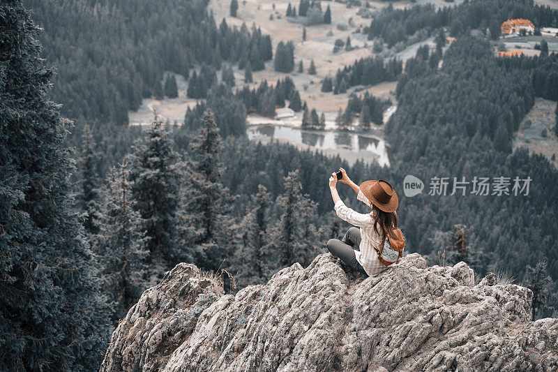 回归自然。独自旅行的人在美丽的全景前从高处。一个快乐的年轻女游客漫步在大自然中。阳光明媚的户外享受。