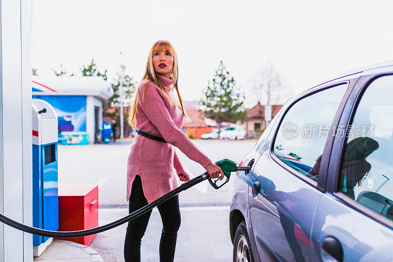 一个女人在加油站给她的车加油
