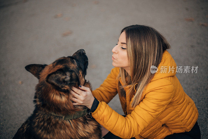 年轻女子和德国牧羊犬在公园里玩