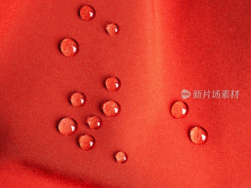 红色运动防水织物上的雨滴