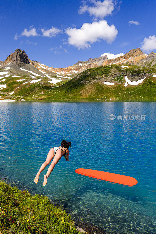 女性桨板跳水到高山湖泊