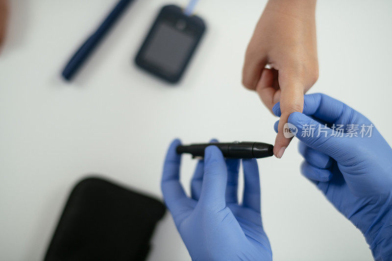 用血糖仪测量女孩的血糖水平照片。