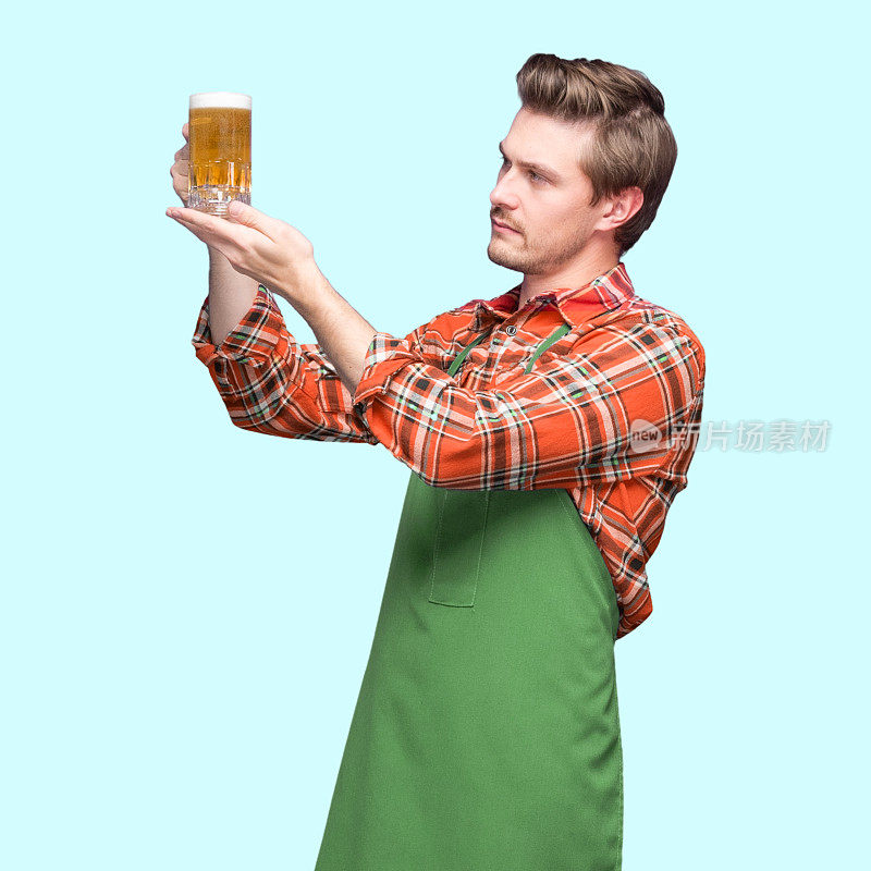 酿酒师——白人体力劳动者站在蓝色背景前，穿着伐木工衬衫，拿着酒杯