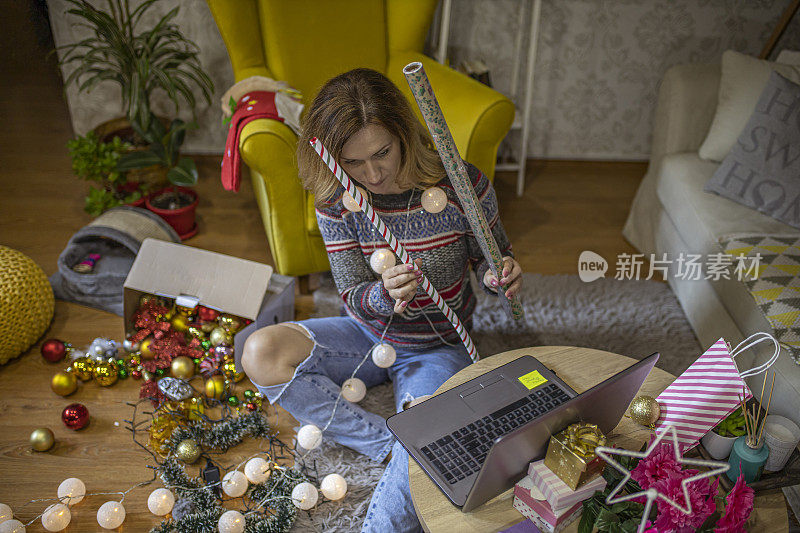 圣诞节期间，一名女子在视频通话中向家人展示装饰纸