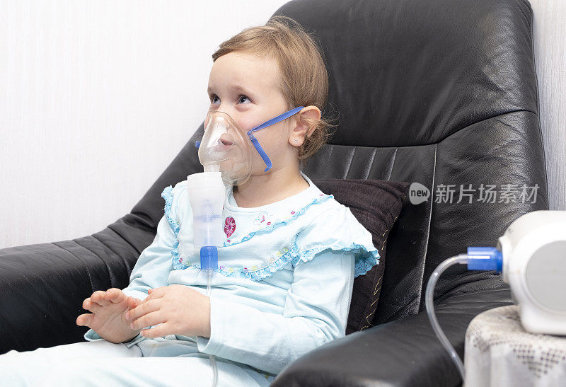 一个5岁的女孩，用喷雾器吸入。