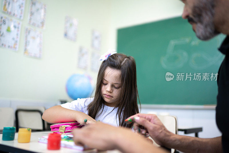 有特殊需要的学生在学校艺术课上得到老师的帮助