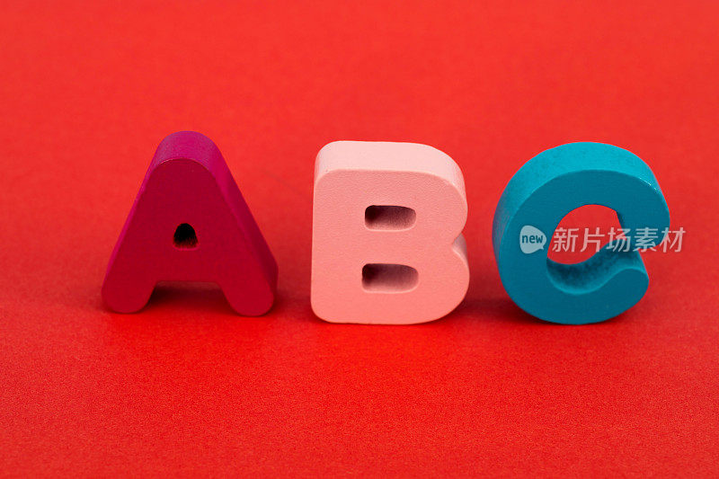 红色背景上的木制大写字母A、B、C