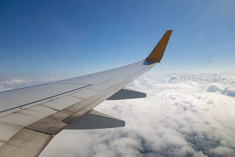 飞机的机翼在天空的云上面飞行