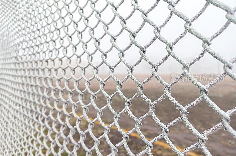 网栅栏上结霜。寒冷的冬天的天气。