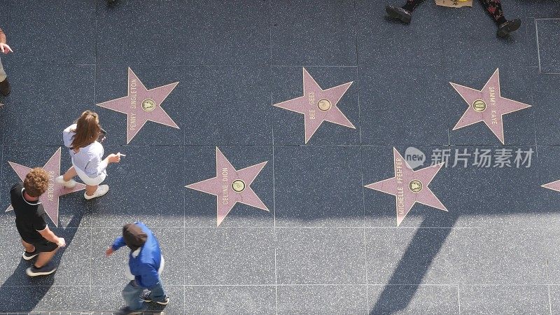 洛杉矶好莱坞大道上的星光大道。在柏油路上靠近明星的行人。杜比和TCL中国剧院附近的走道
