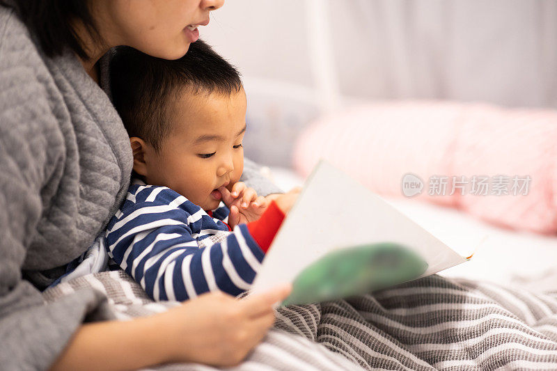 家人睡觉。妈妈和儿子在看图画书