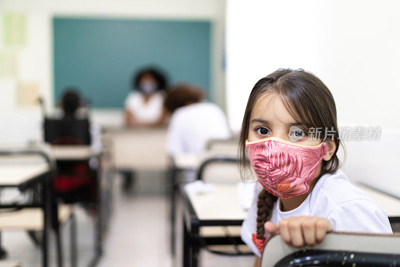 一个女学生在教室里用面具学习的肖像