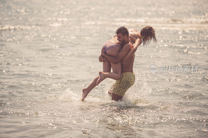 一对年轻夫妇在水里玩得很开心