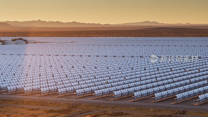 无人机拍摄的抛物线槽太阳能厂和沙漠以外的日出