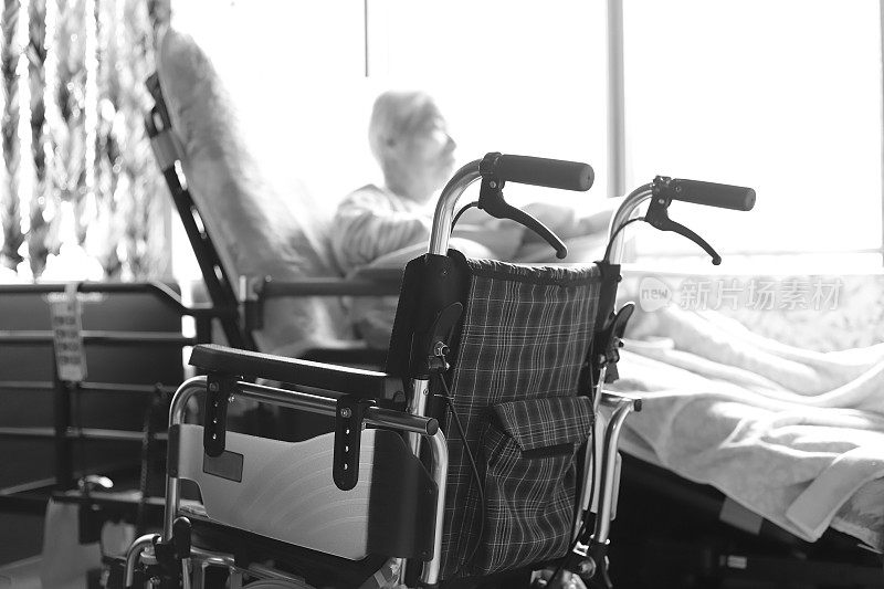 患有痴呆症的老年妇女在护理床上放松时玩着小毛巾