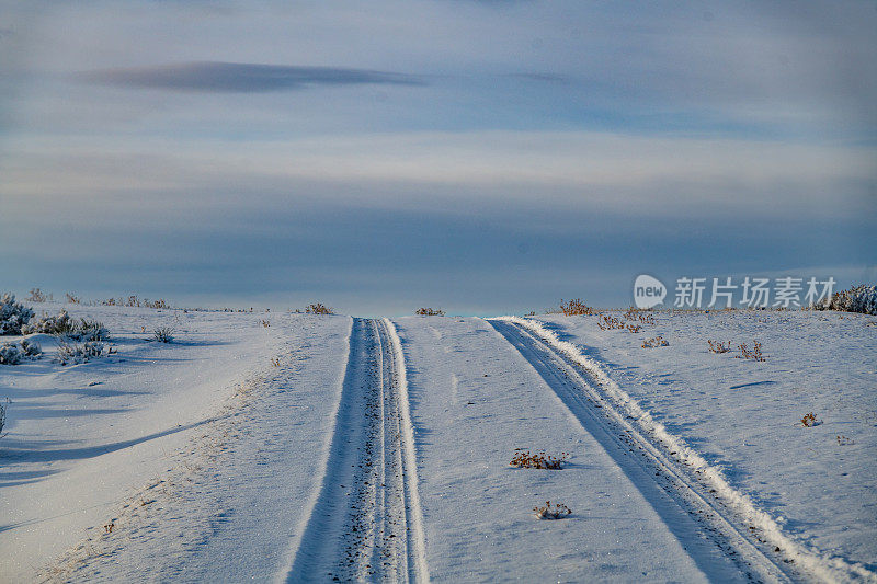 日落时分，蒙大拿山上的泥土路被白雪覆盖