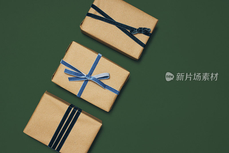 三个精心包装的礼品盒与不同风格的丝带