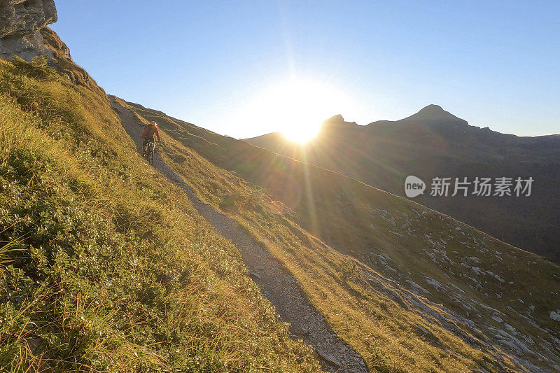 山地自行车手沿着长满草的山脊行进