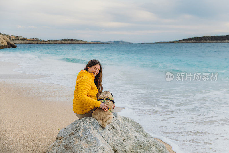 一个女人和她最好的朋友在海滩上享受日落