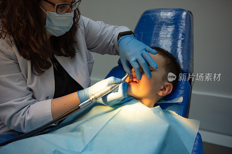 牙科医生为坐在牙科椅上的儿童检查牙齿