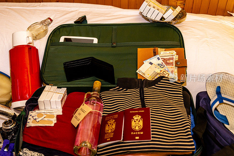 一个装满东西的手提箱和两本准备去度假的护照。