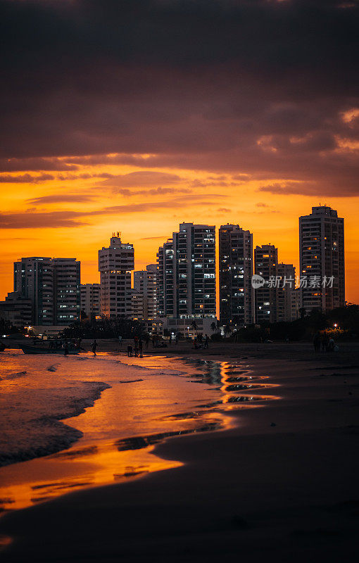 日落时以建筑物为背景的海滩全景