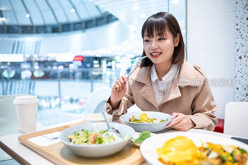 亚洲年轻女子在餐厅吃饭