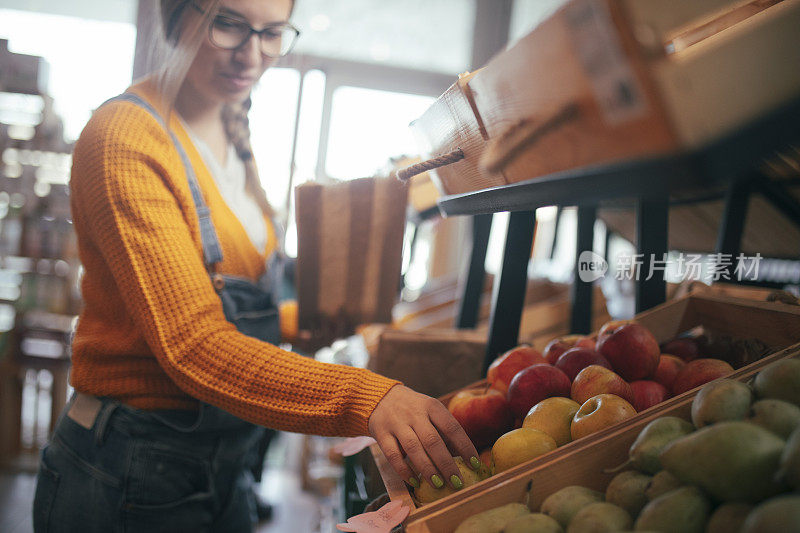 一个健康饮食的快乐女人会买水果和蔬菜。