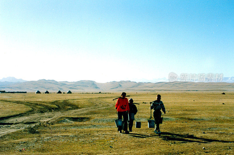 在巴音布鲁克草原上，蒙古妇女每天早上挑水