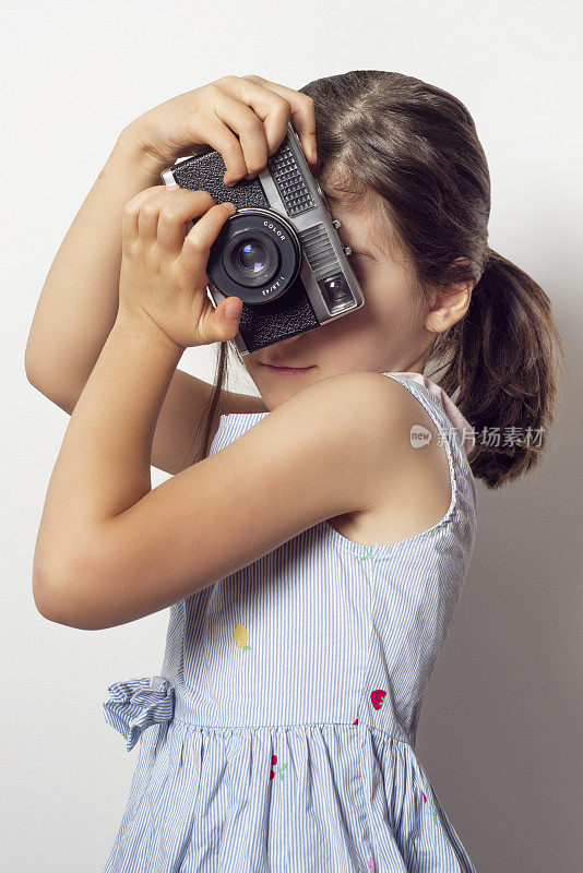 垂直拍摄一个可爱的女孩用老式胶卷相机拍照