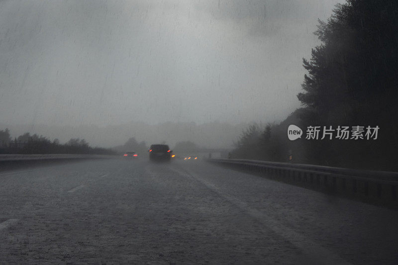 高速公路上的大雨，红色尾灯模糊的汽车，黑暗的道路上的水滴和水，开车时的危险天气，交通和运输的概念，复制空间