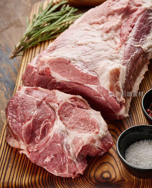 猪颈肉放在木板上。新鲜的猪颈肉加盐和胡椒粉。